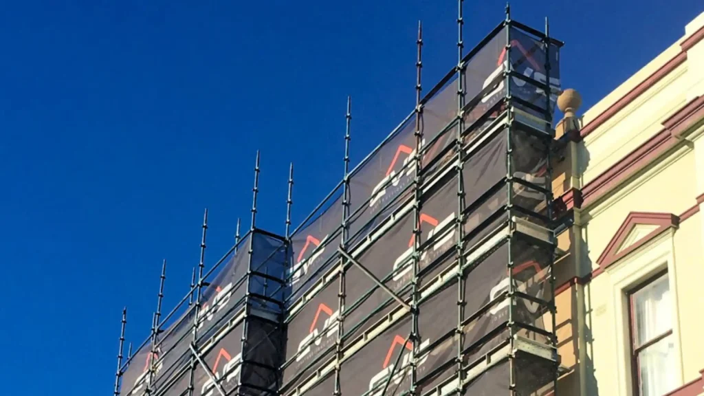 Shade cloth scrim on scaffolding at a construction site.