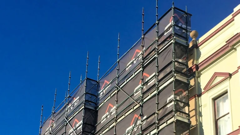 Shade cloth scrim on scaffolding at a construction site.